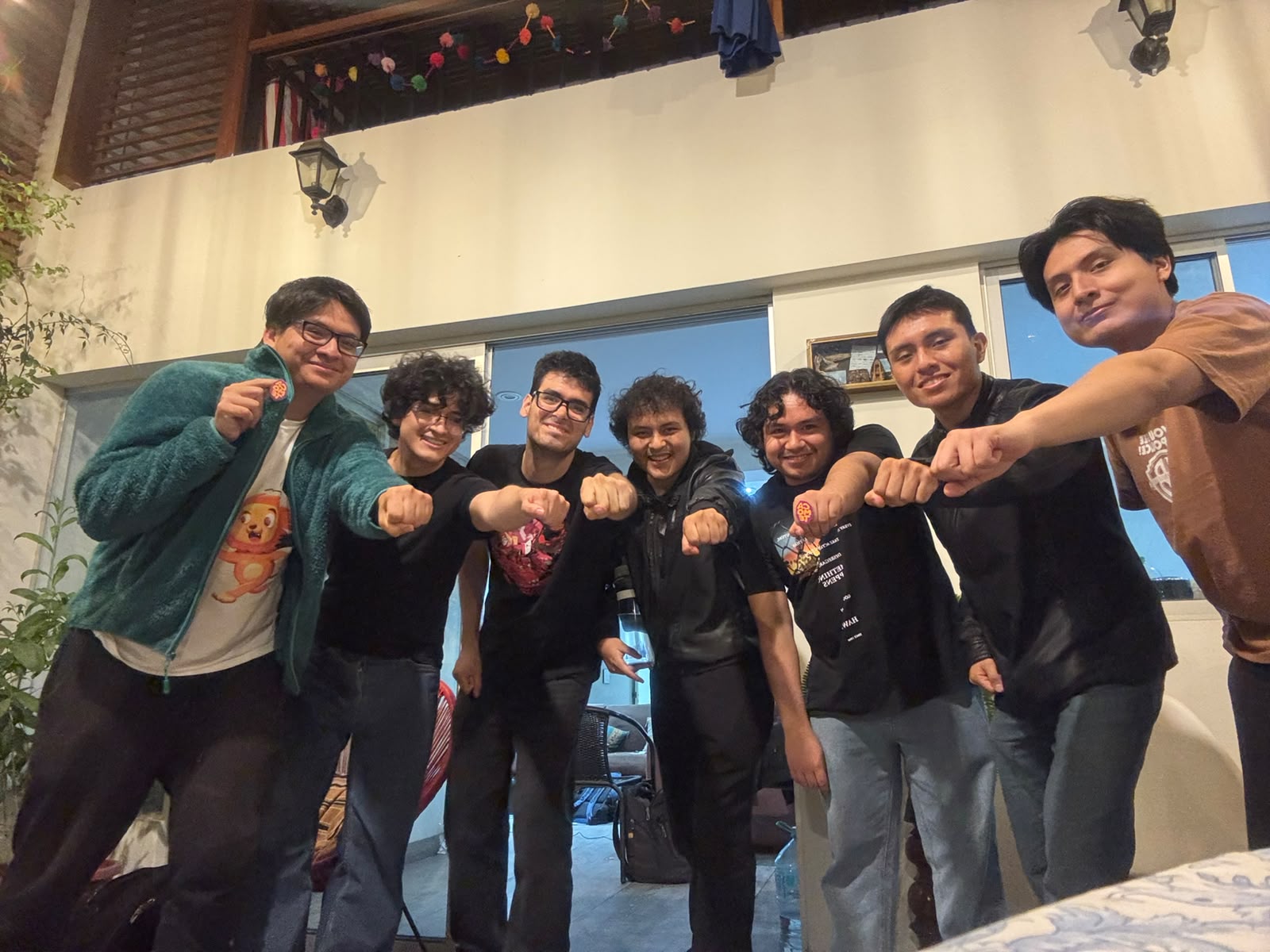 El equipo de Camote Studio reunido, mostrando sus puños y la marca del estudio.